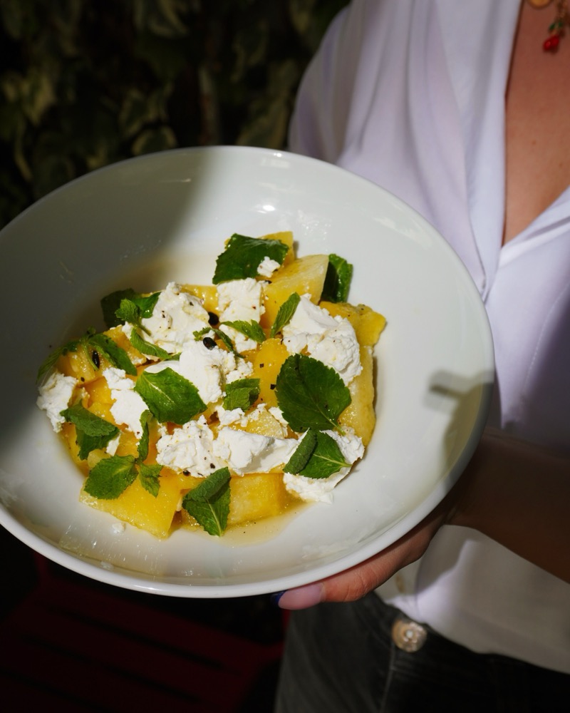 Melon salad with ricotta and mint held at the table