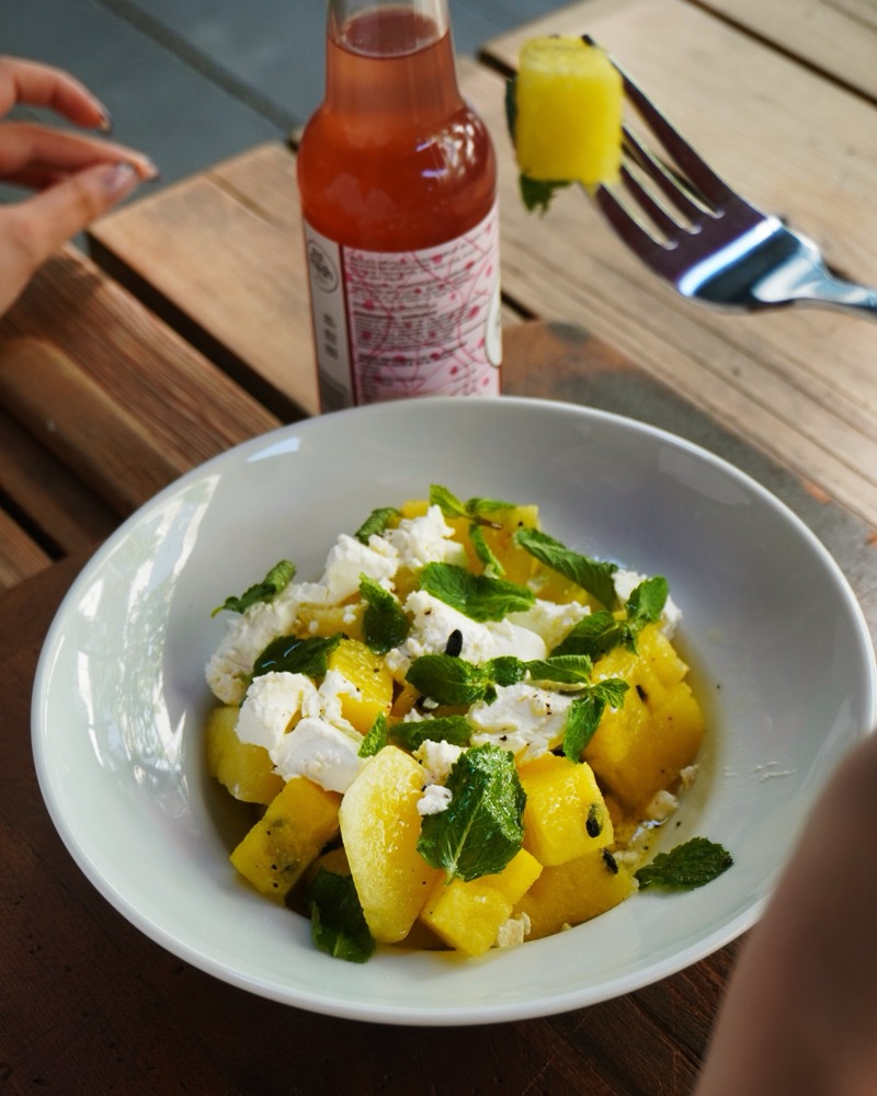 Melon salad served outdoors with a cold drink
