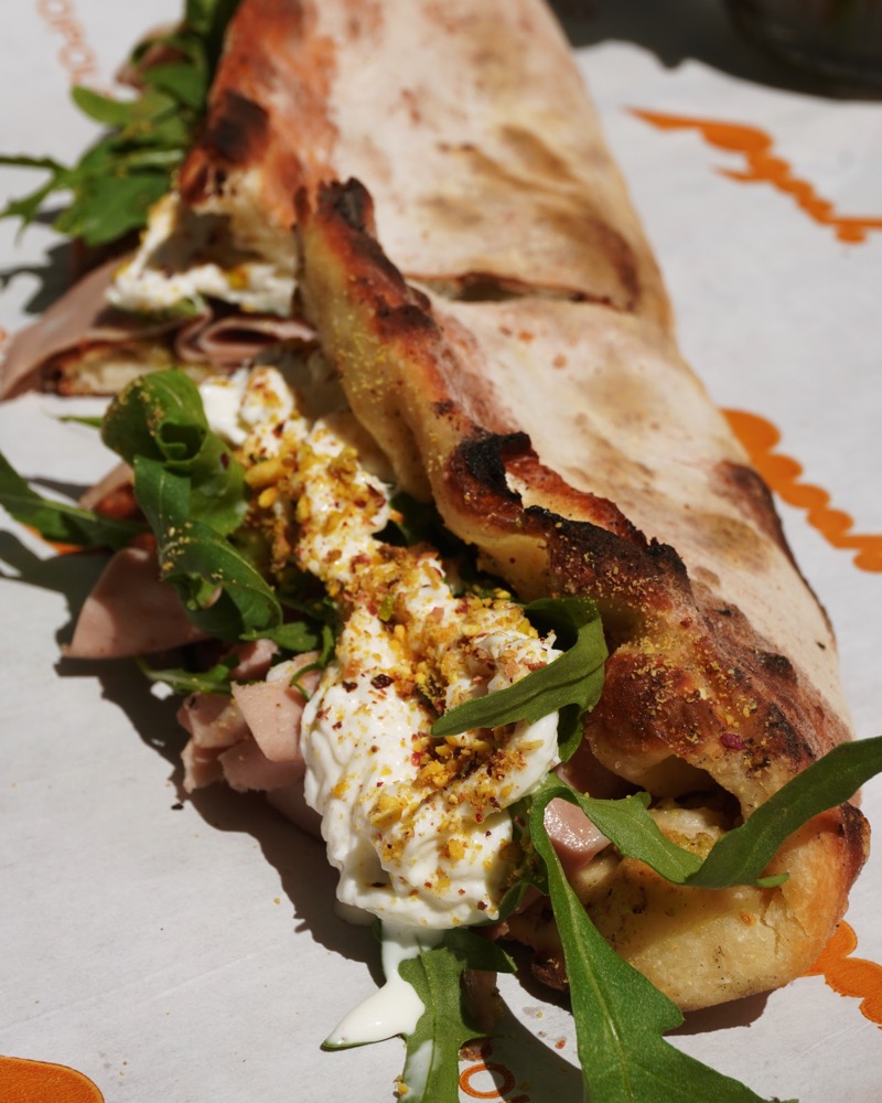Close-up of a panuozzo filled with mortadella and stracciatella