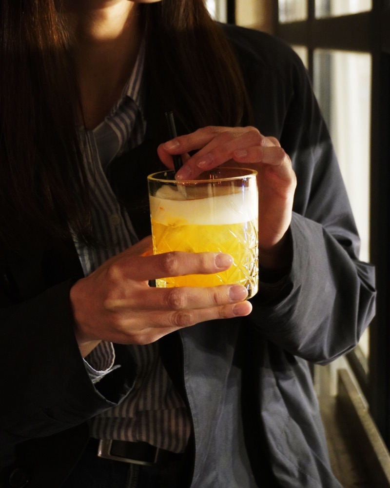 A beer cocktail held in warm evening light